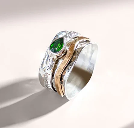 Chunky spinner ring made in silver and gold with green gemstones